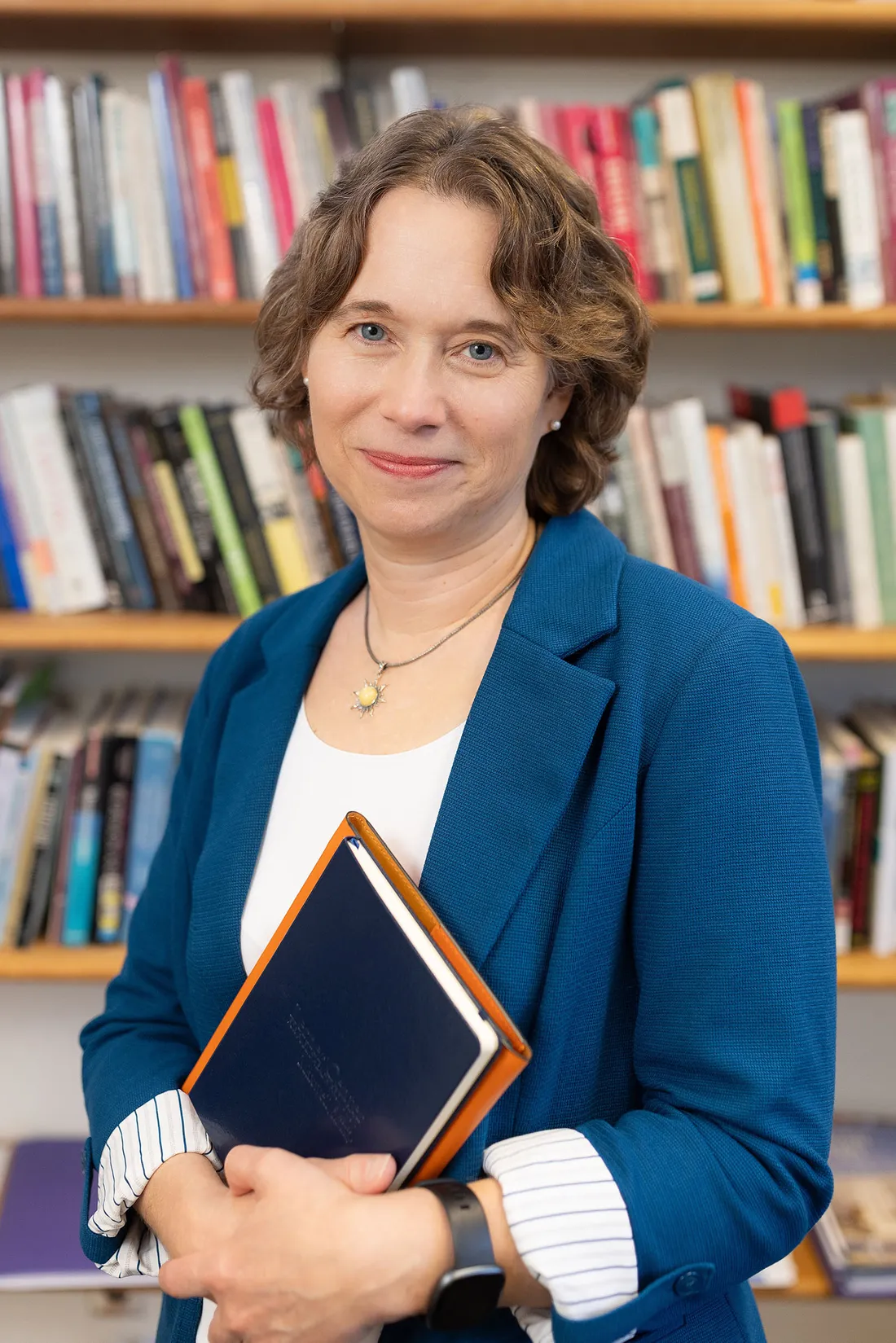 Colleen Heflin holding a book in her office.