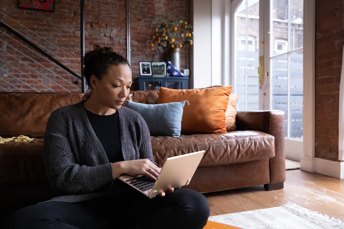 Person sitting on a couch using their laptop.