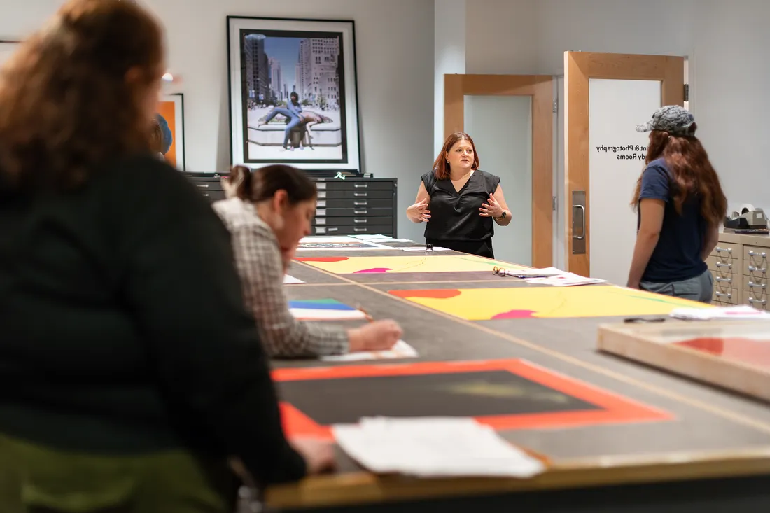 Professor talking to a class a of students in an art studio.