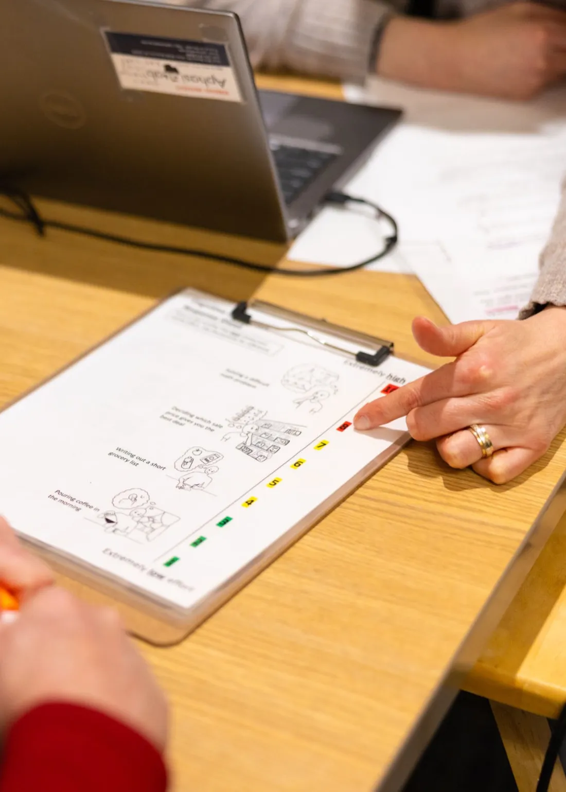 Stroke aphasia researcher pointing to an information sheet for a stroke aphasia patient.