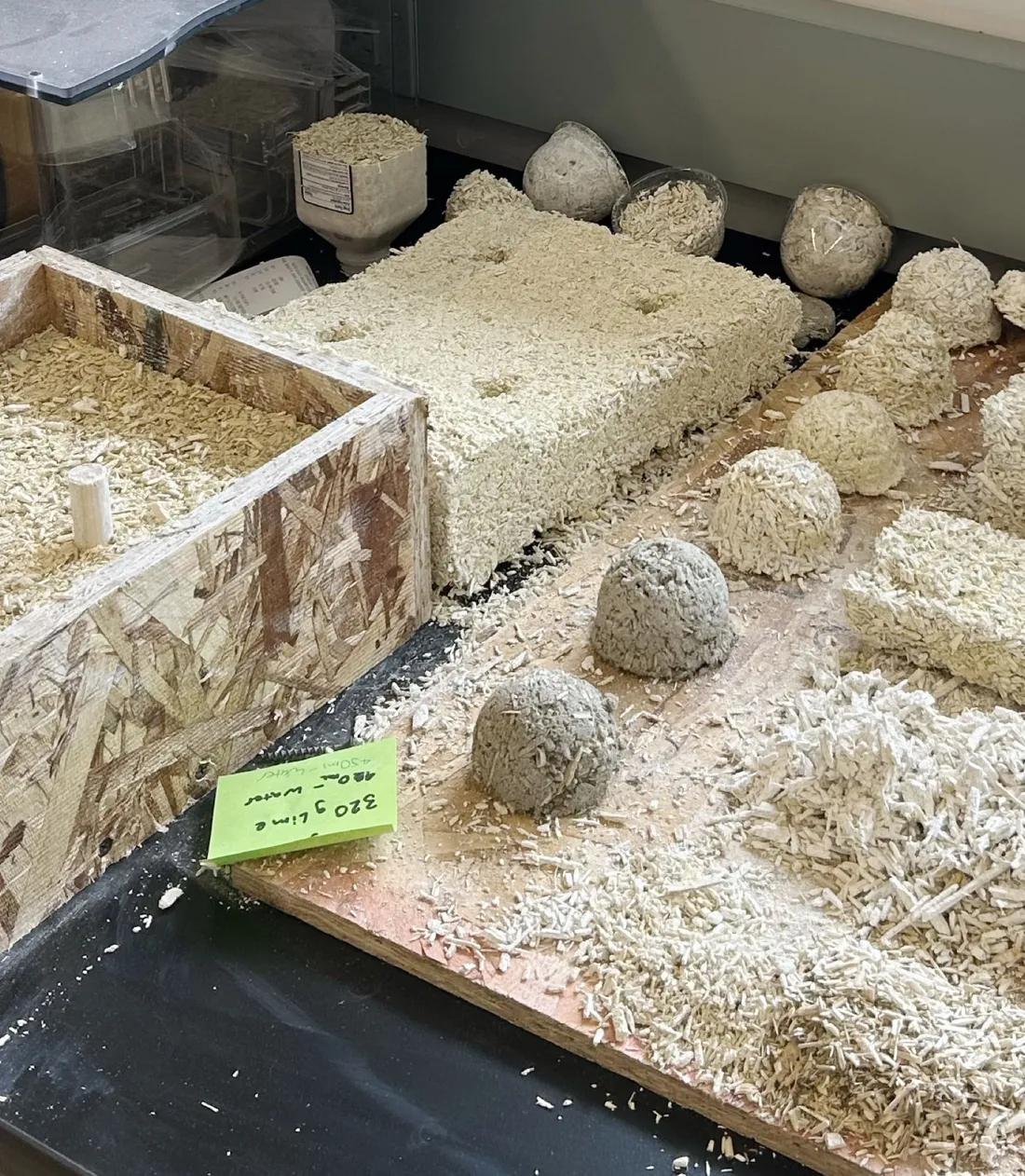Sustainable materials like hempcrete and adobe bricks sitting on a table.