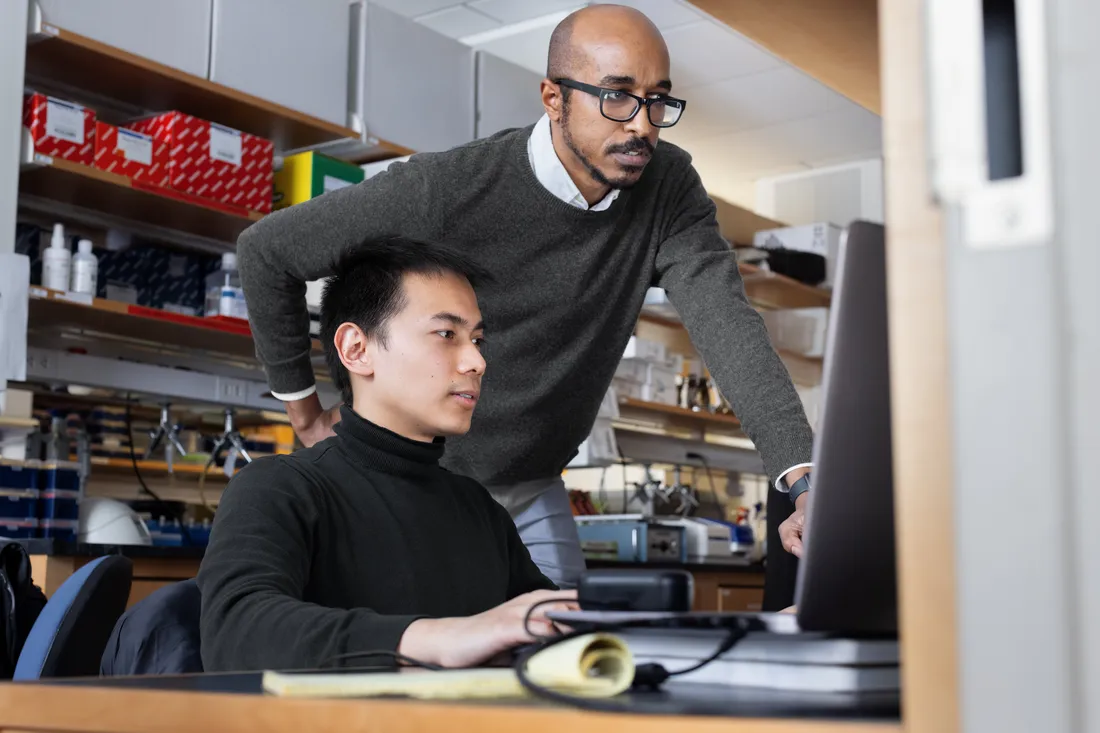 Professor and student looking at computer screen.