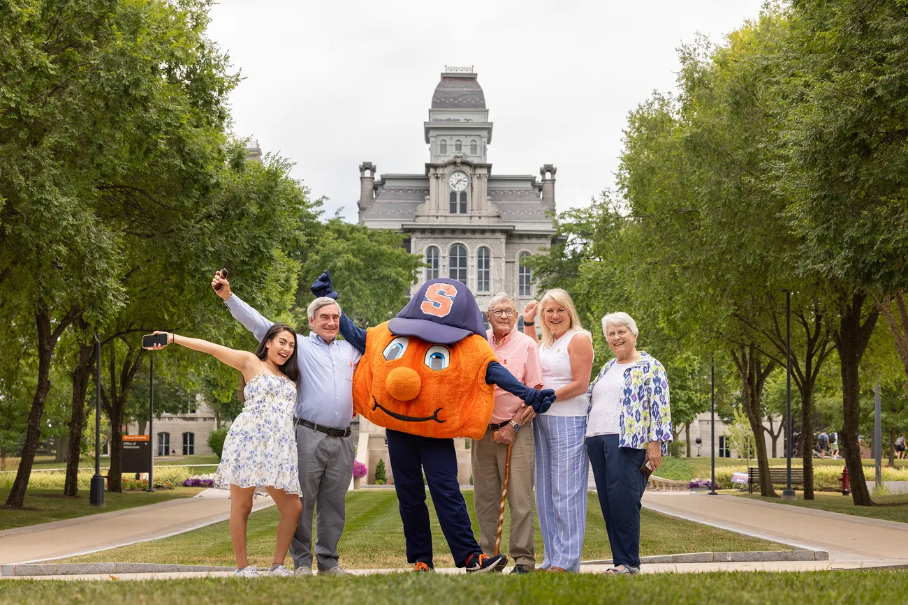 A family posing for picture with Otto in front of the Hall of Languages.