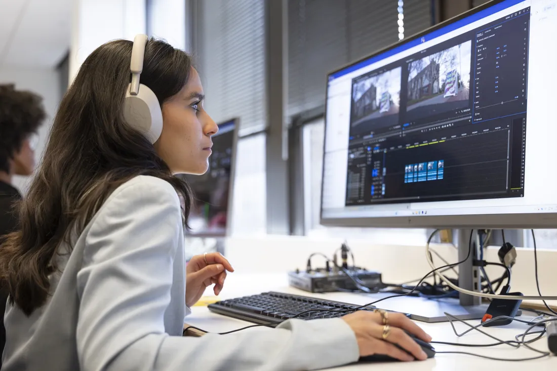 Person sitting behind computer editing a video.