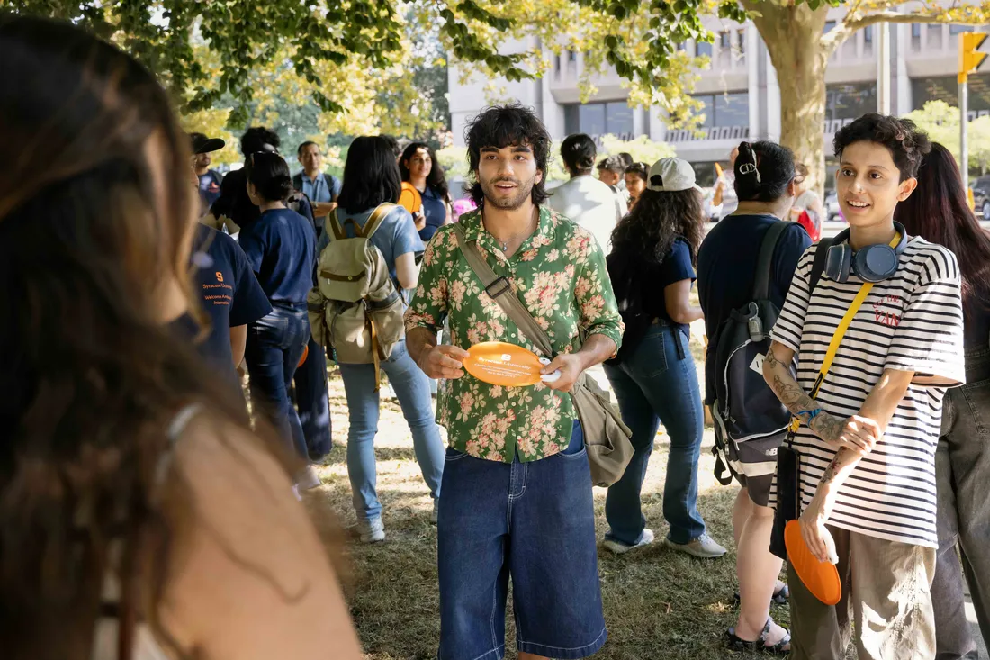 Two international students standing together and smiling at an event.