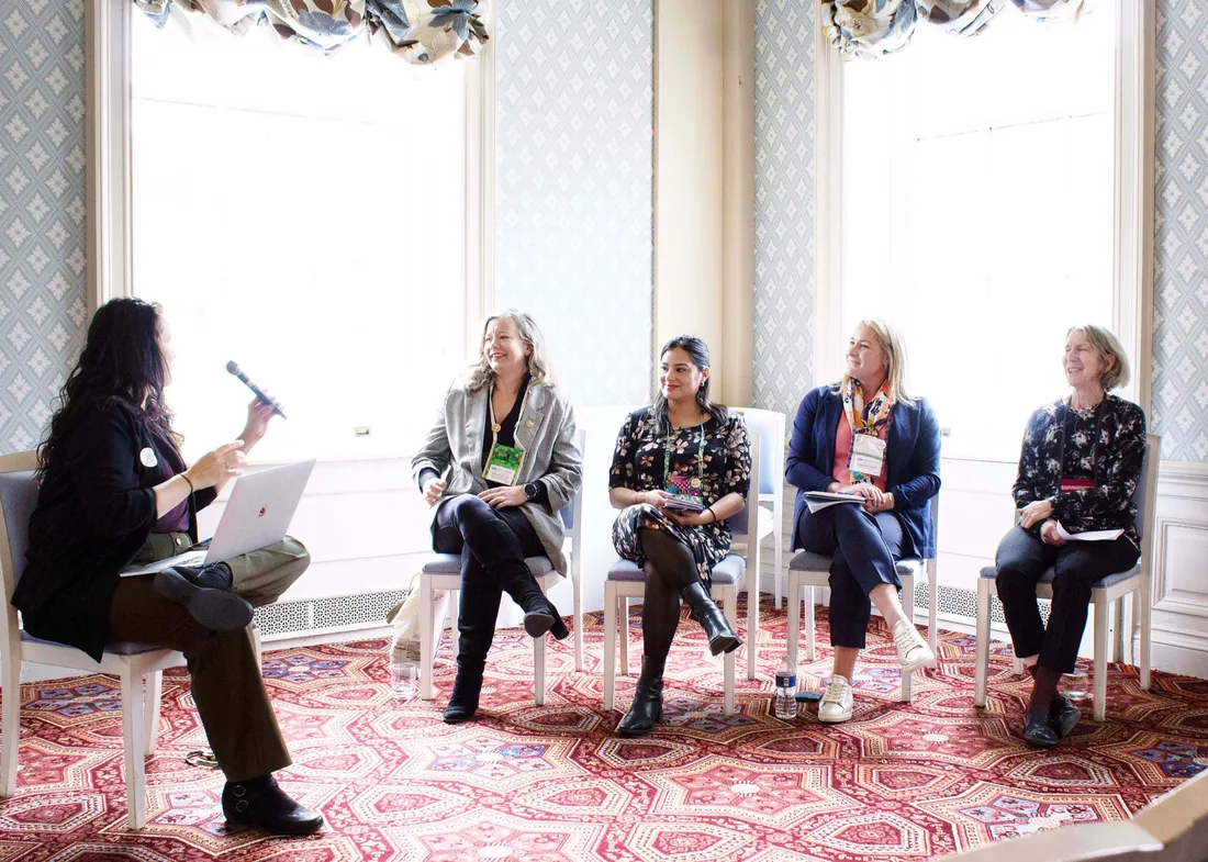 Melissa Young moderating a women-led panel with four other women leaders.
