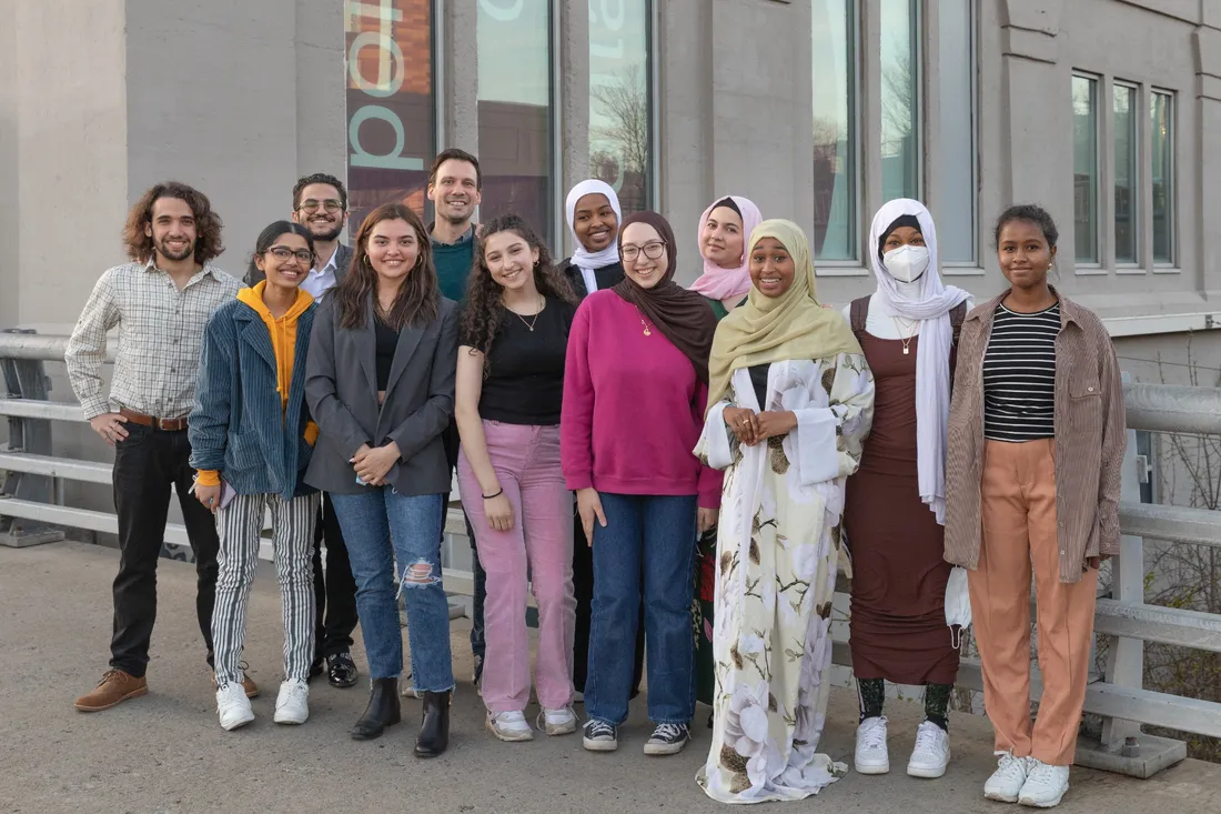 A group of students stands in front of a building.