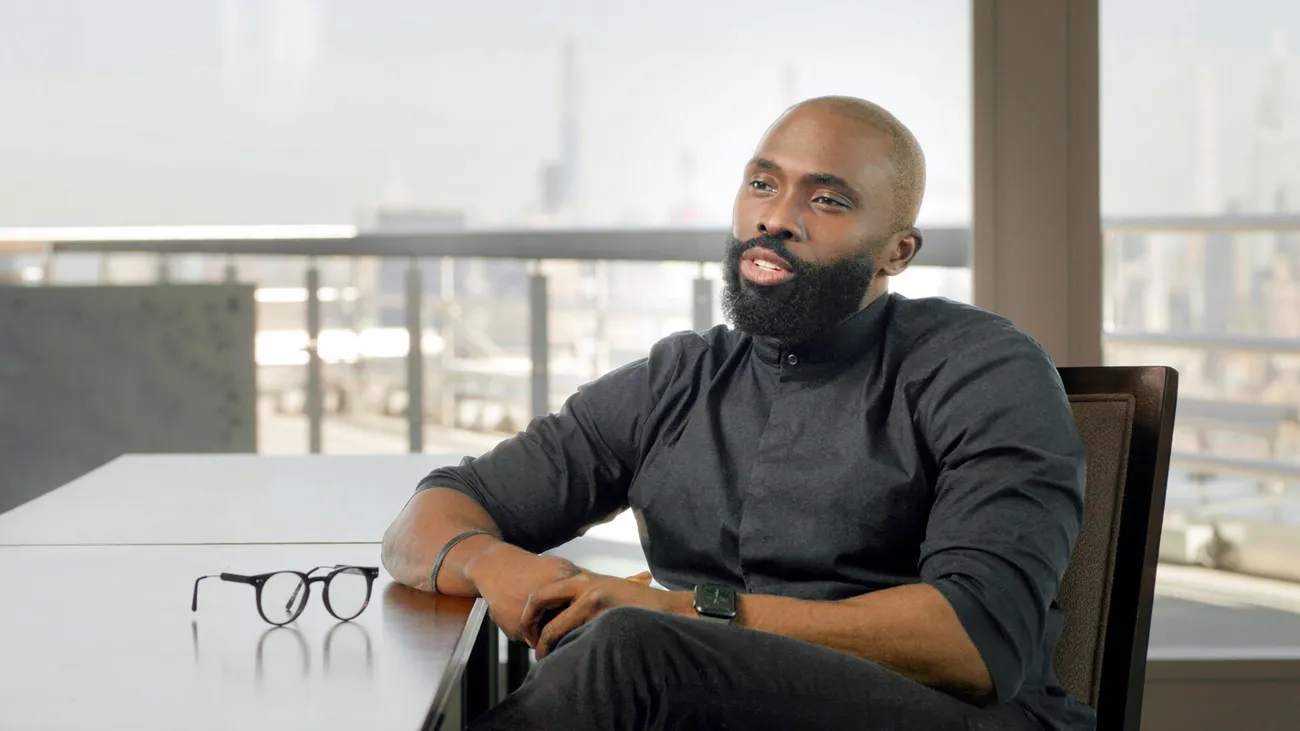 Person sitting at a desk talking.