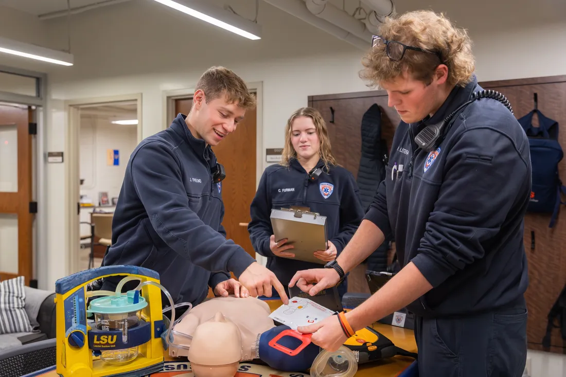 Person teaching students CPR on a dummy.