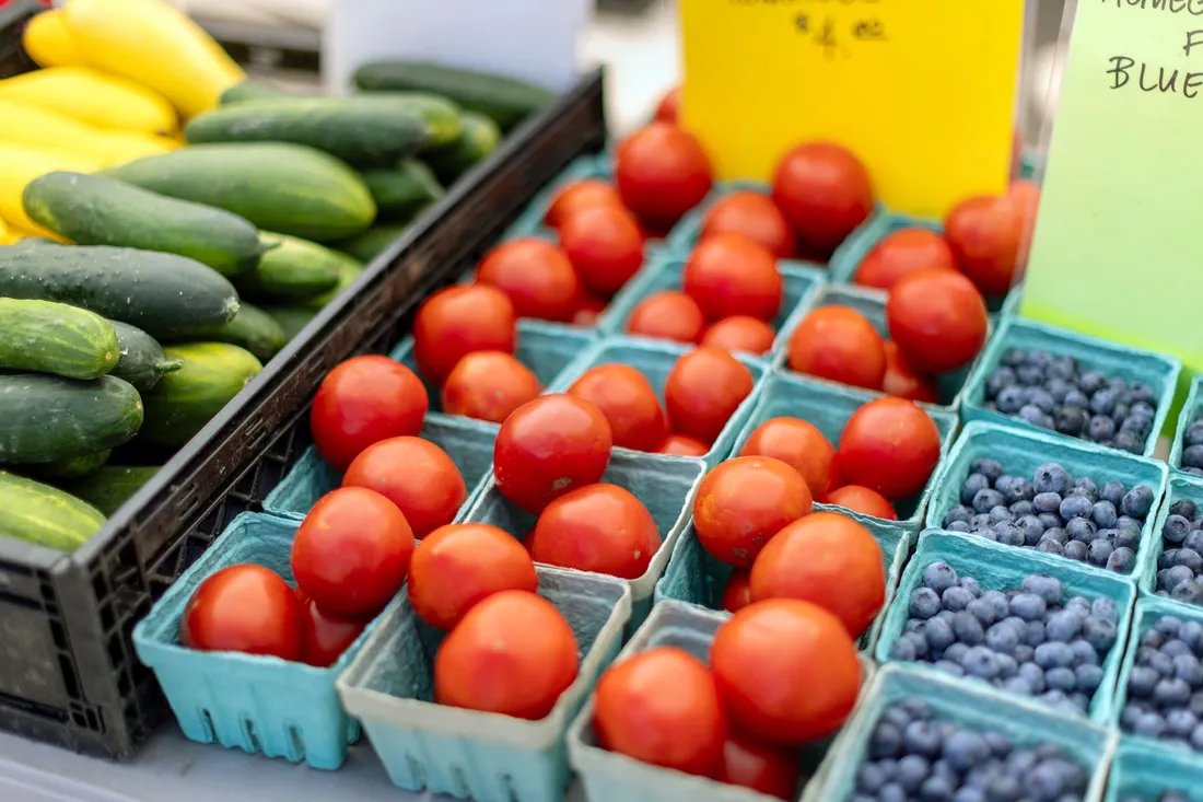 Cucumbers, tomatoes, blueberries at a farmers market