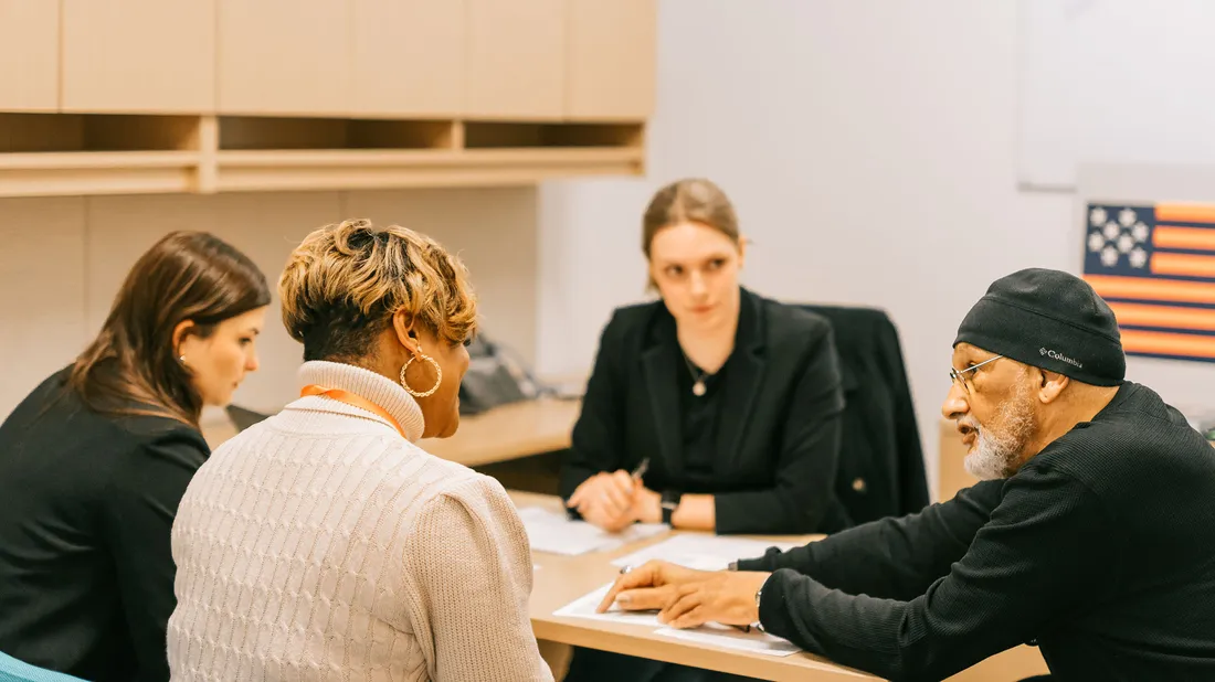 People working around a table at the Veteran Legal Clinic.