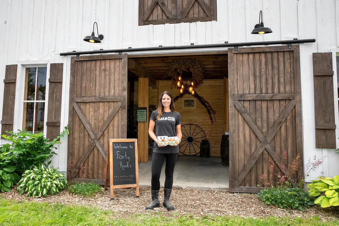 Chaya Charles stands in front of barn.