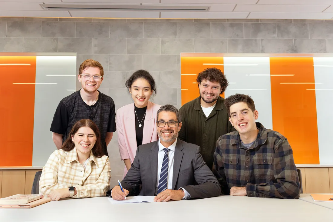 Dean Jordan smiling in a group with students.
