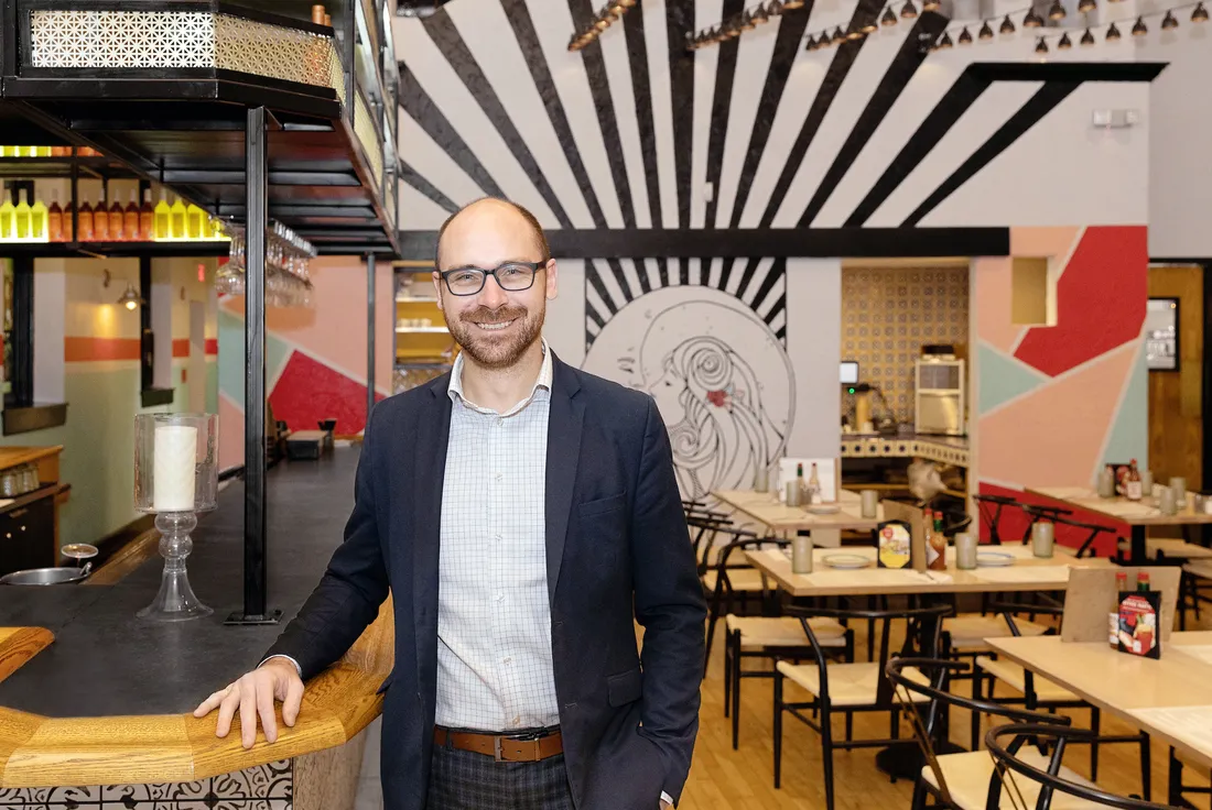Alumnus Ryan Benz standing in a restaurant.