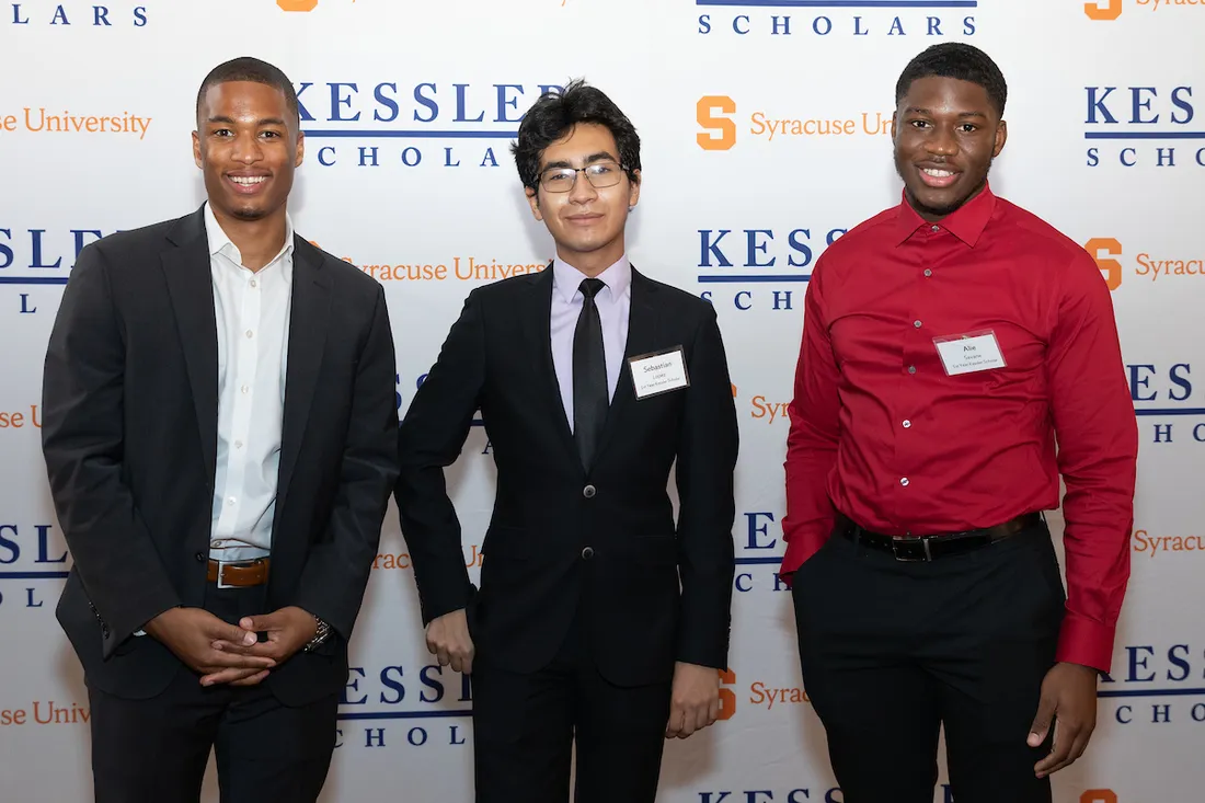 Students standing and smiling.