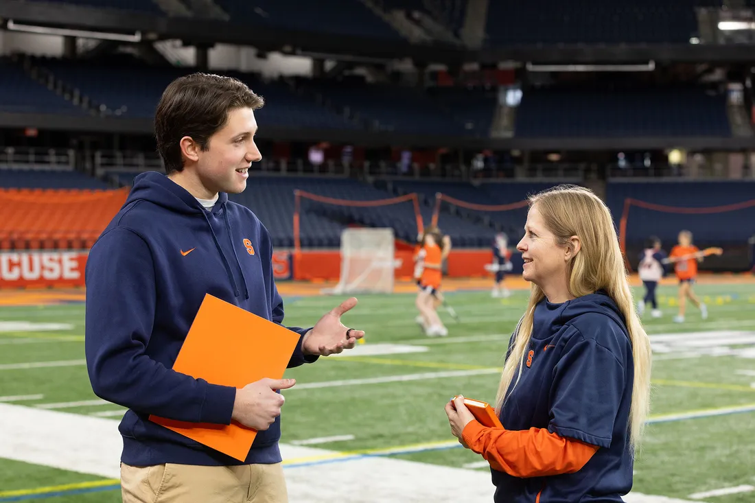 Caden Lippie talking to a woman on a field.