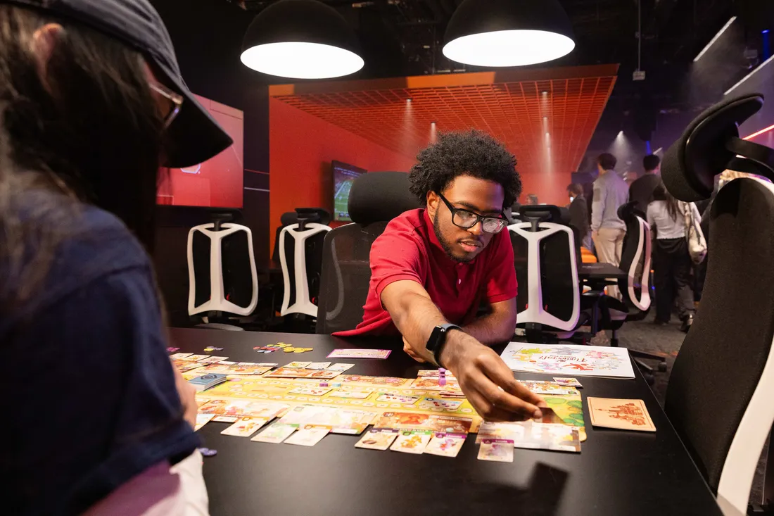 Students in Esports room gather looking at cards.