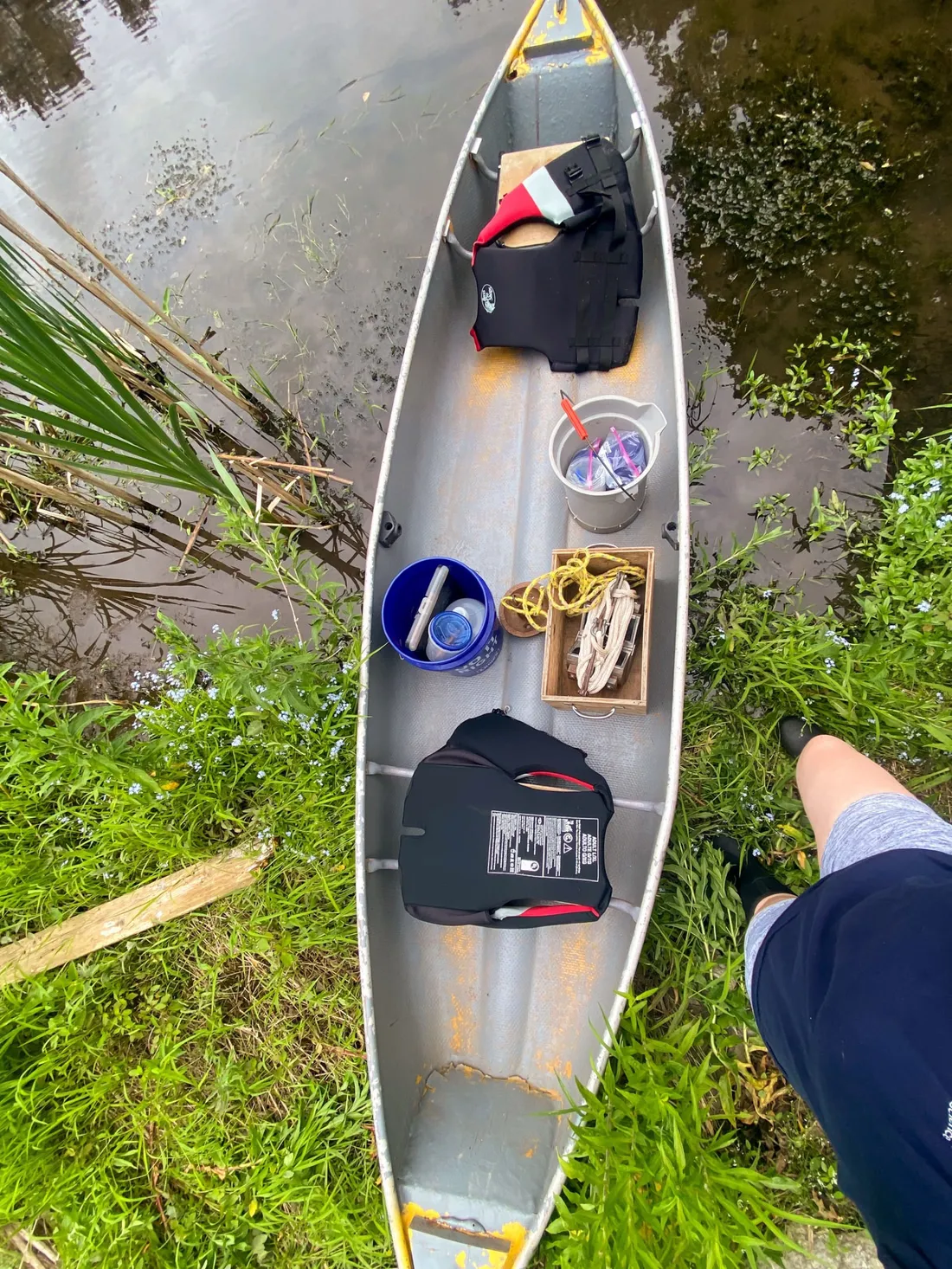 Canoe filled with environmental surveying tools resting on a creek bed.