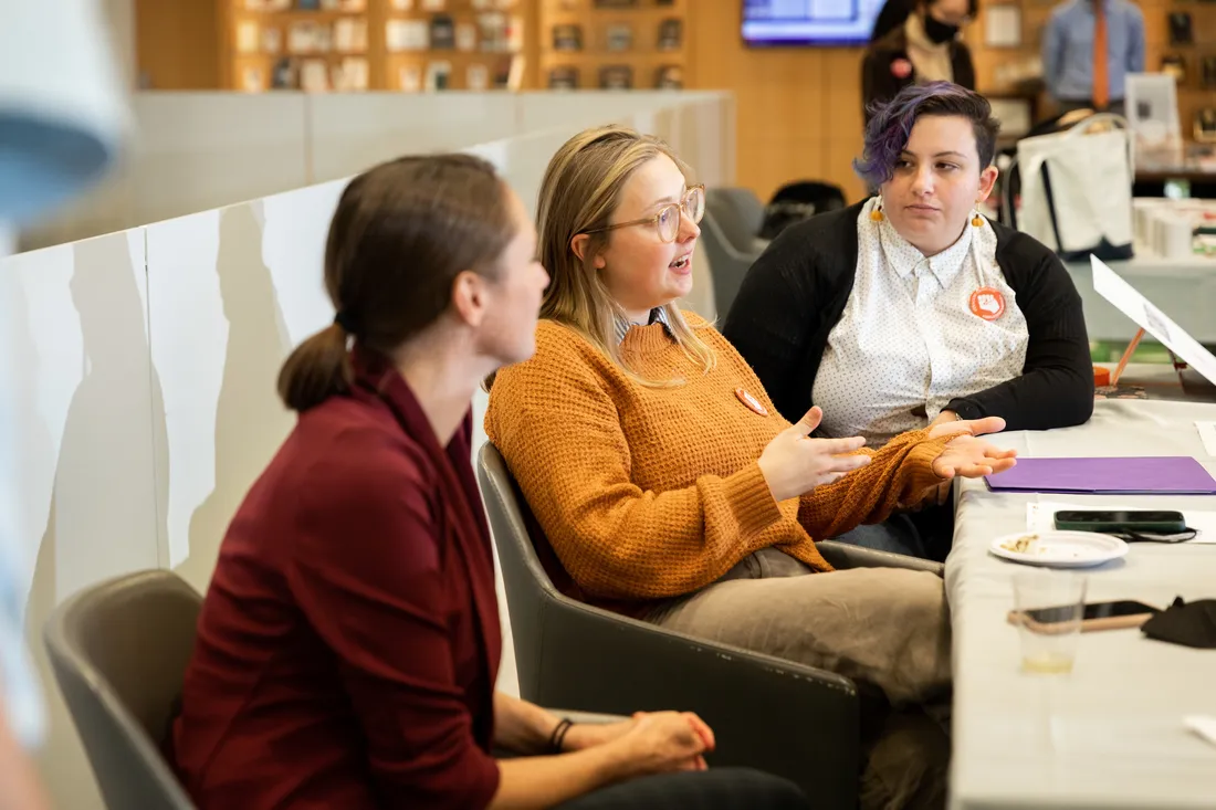 People have a conversation at a table.