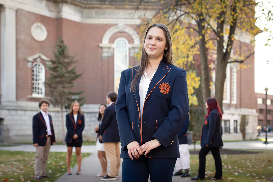 Portrait of Madison Prowak outside, smiling with hands clasped in front.