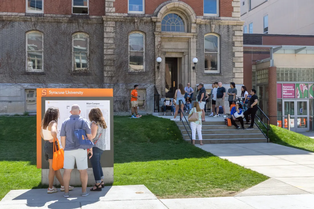 People standing on Syracuse University's campus looking at a map.