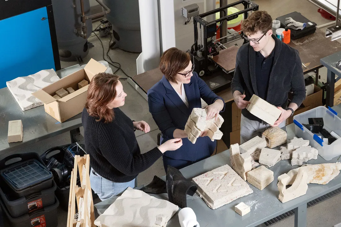 Three people together looking at building materials.