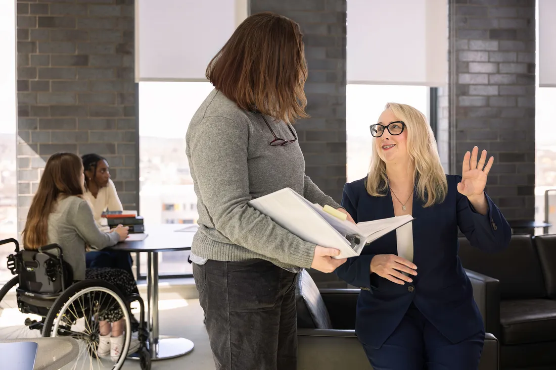 Kat MacFalane talking to a student with her hand up.