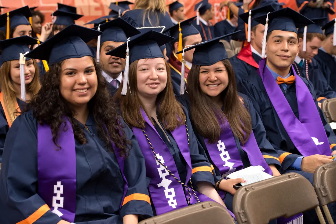 Native American studnets in their graduation caps and gowns at Commencement.