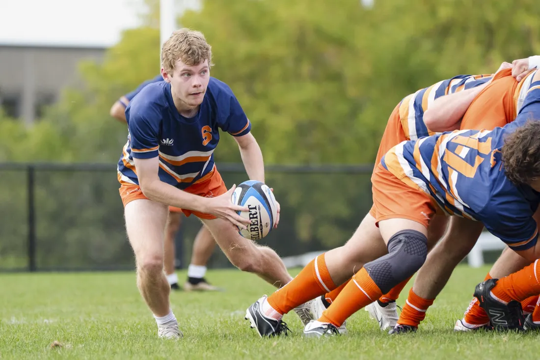 Member of the men's club rugby team running with a rugby ball.