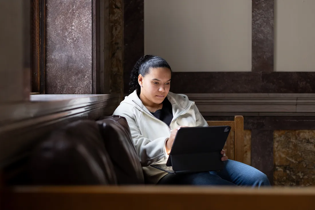 Person sitting and studying on couch.