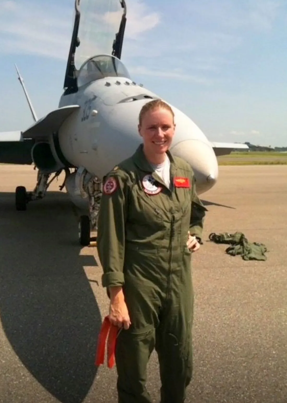 Laurie Coffey veteran posing in front of airplane.