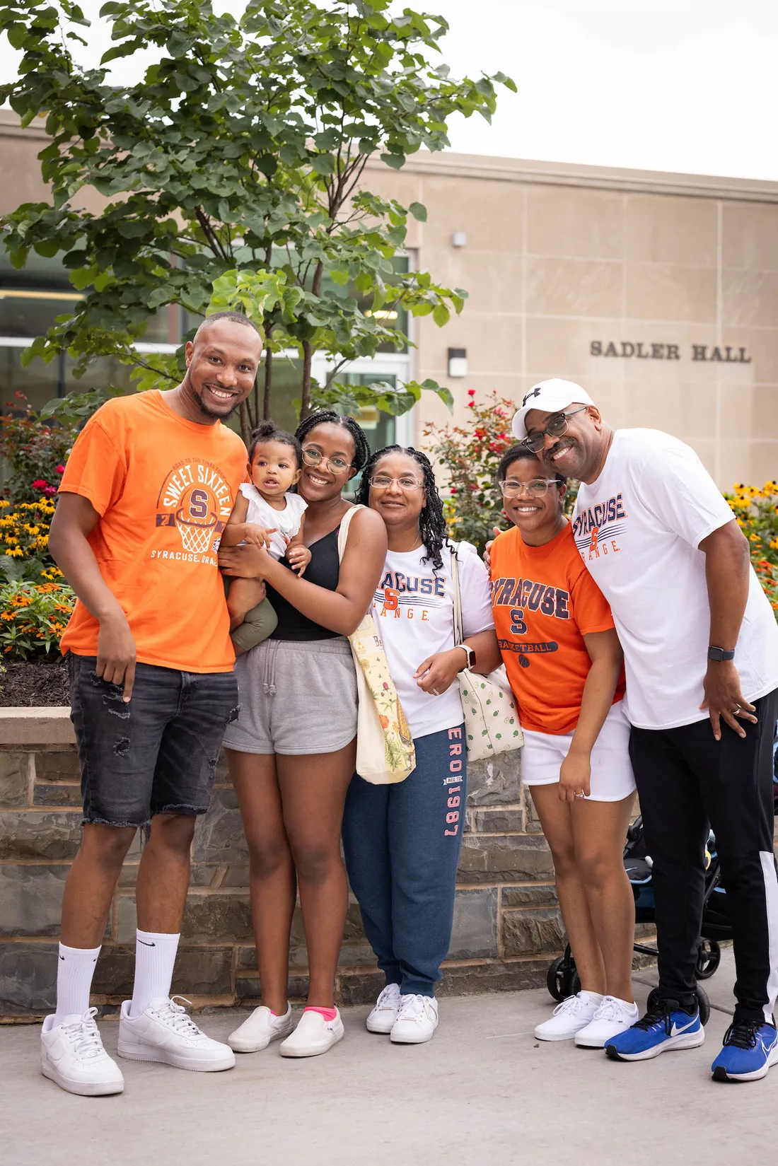 Family of 7 poses for photo together wearing Syracuse pride tee shirts.