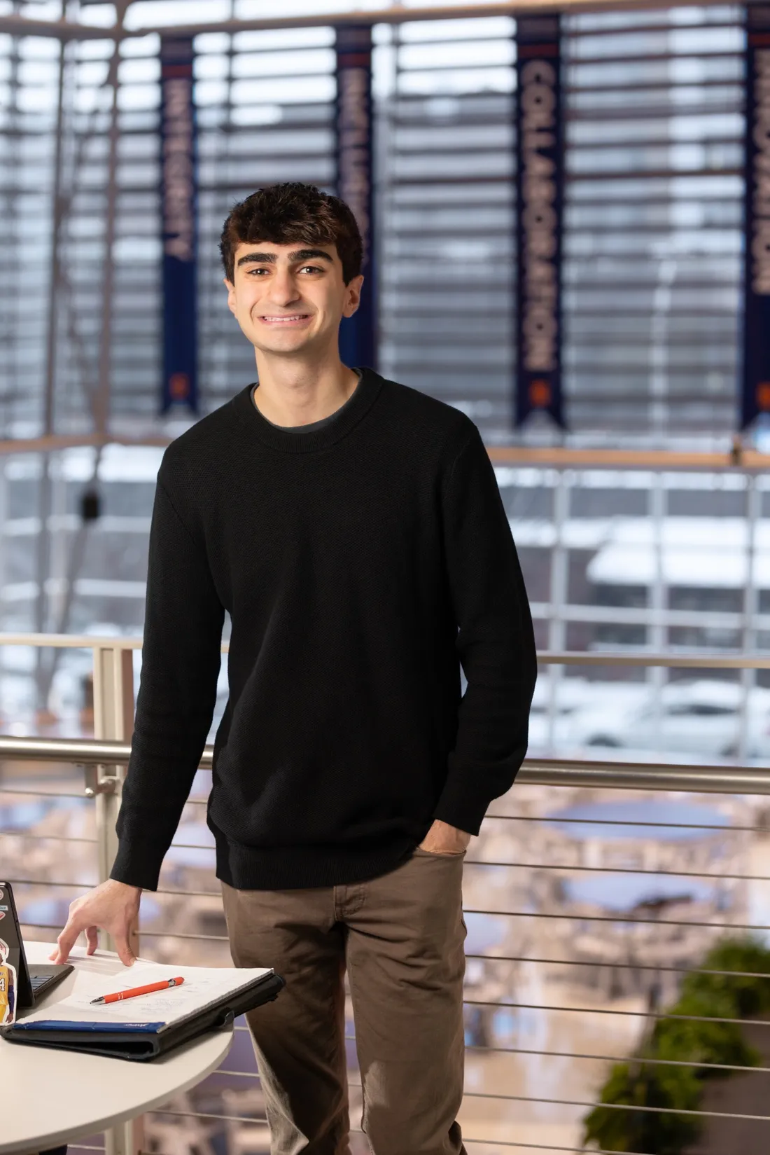 Person standing and smiling in the Martin J. Whitman School of Management.