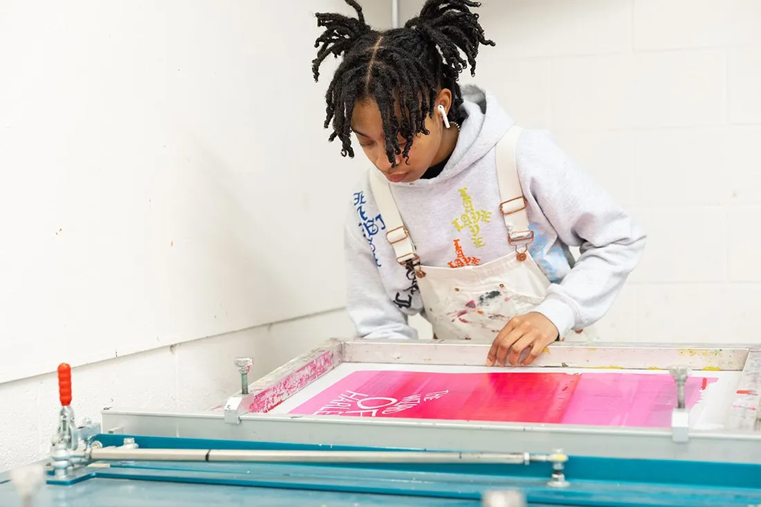 Person using screen printing tools.