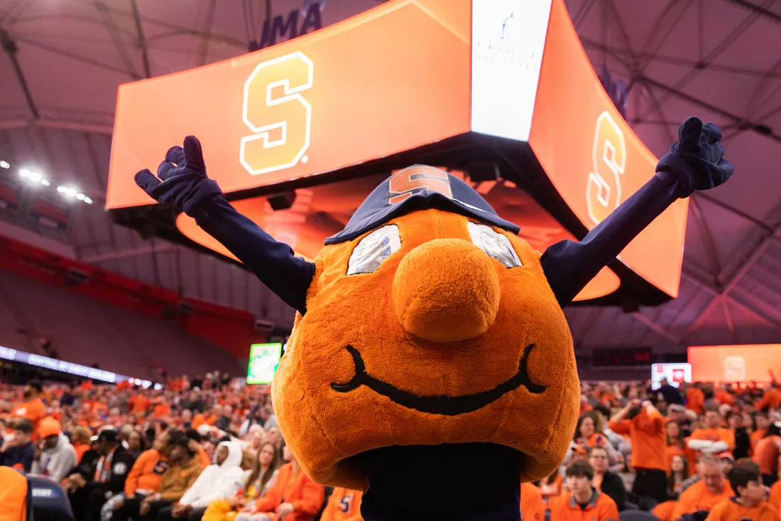 Otto in front of the scoreboard and crowd at a basketball game at the JMA Wireless Dome.