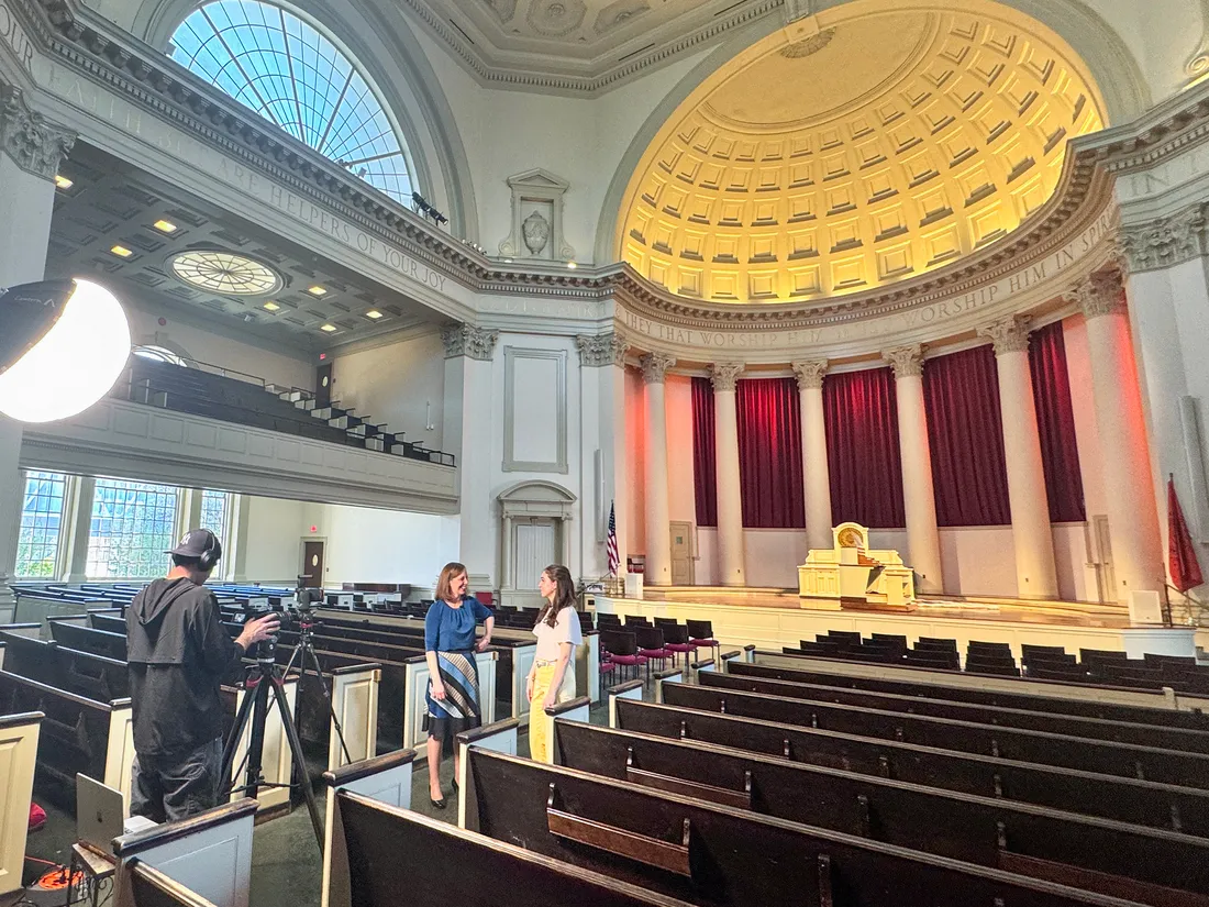 People talking in a church while making a film.