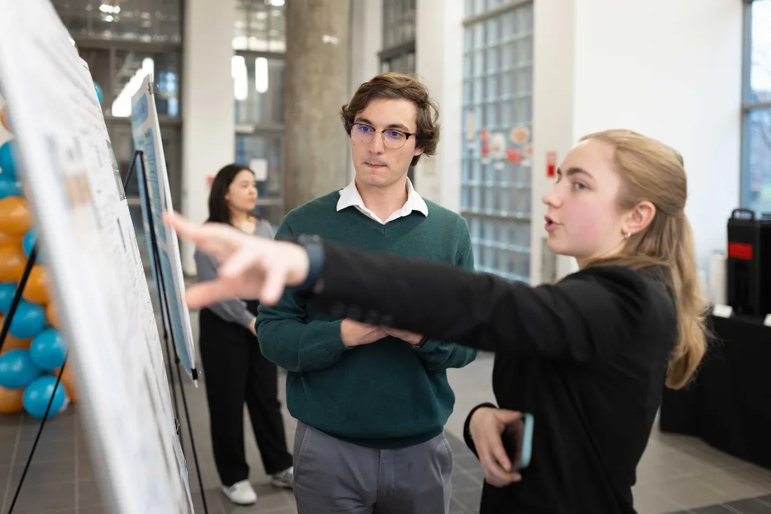 Two students looking at a presentation on a board.