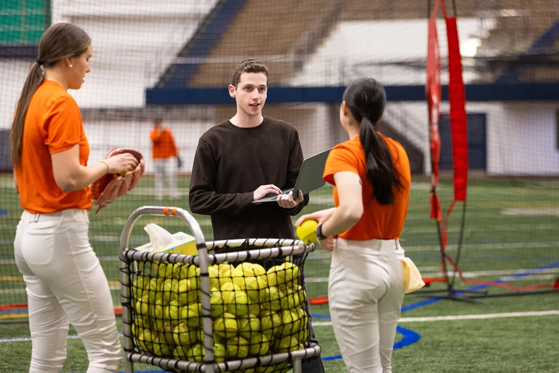 Gavi Sela talking to two female softball players.
