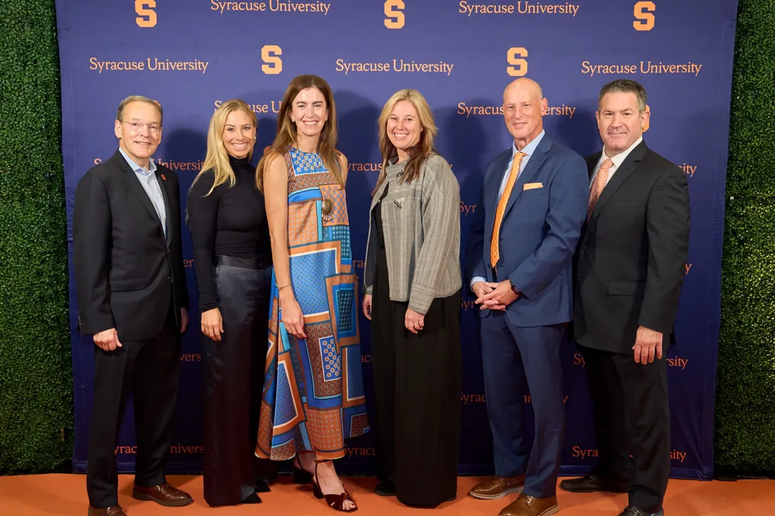 Six people standing together and smiling.