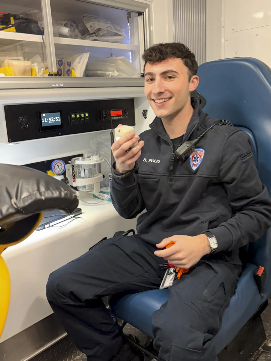 Beckam Polis ’28 sitting in the back of an ambulance using equipment.