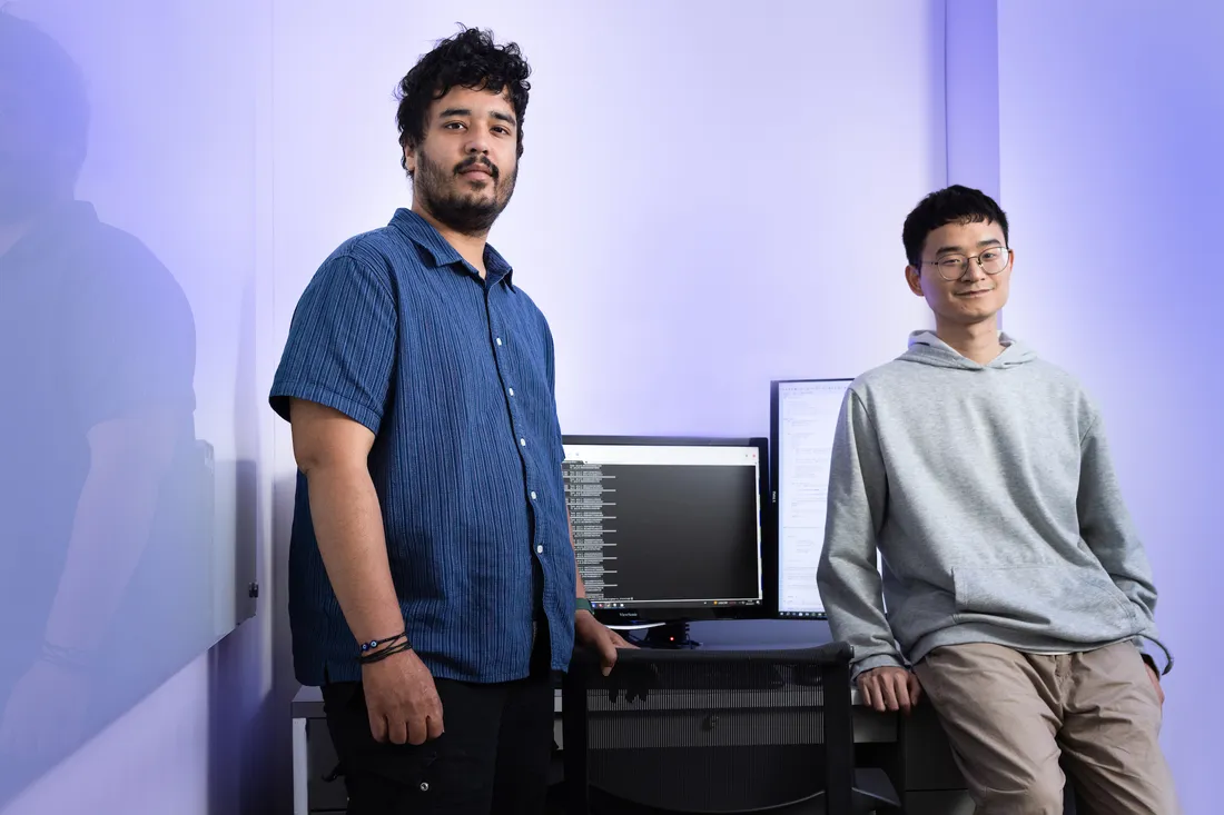 Two students standing together in a computer area.