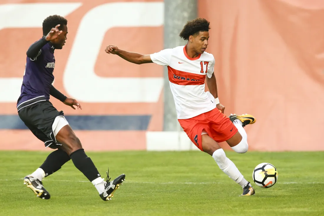 Soccer athlete Tajon Buchanan kicking a soccer ball during a game.