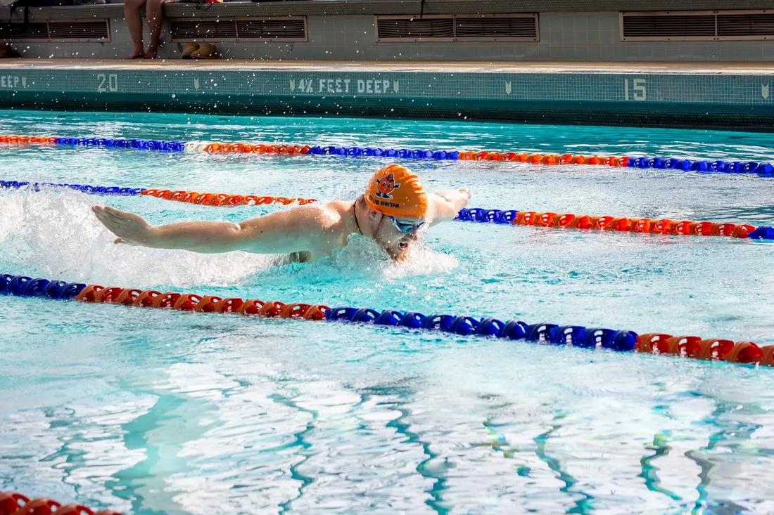 Student athlete on the club swimming team swimming down a pool lane at a meet.