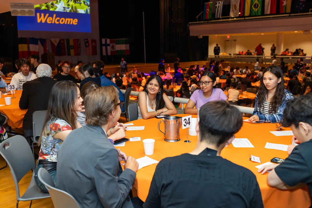 Students sitting at a table at the International Students Welcome dinner.