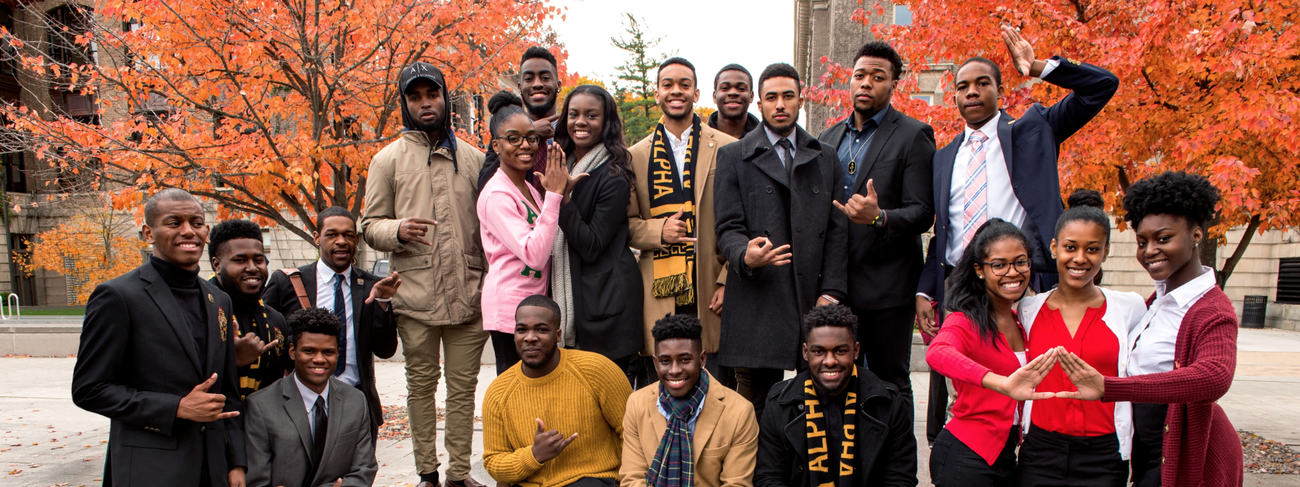 Greek life students pose for a group photo at the Orange Grove in autumn.