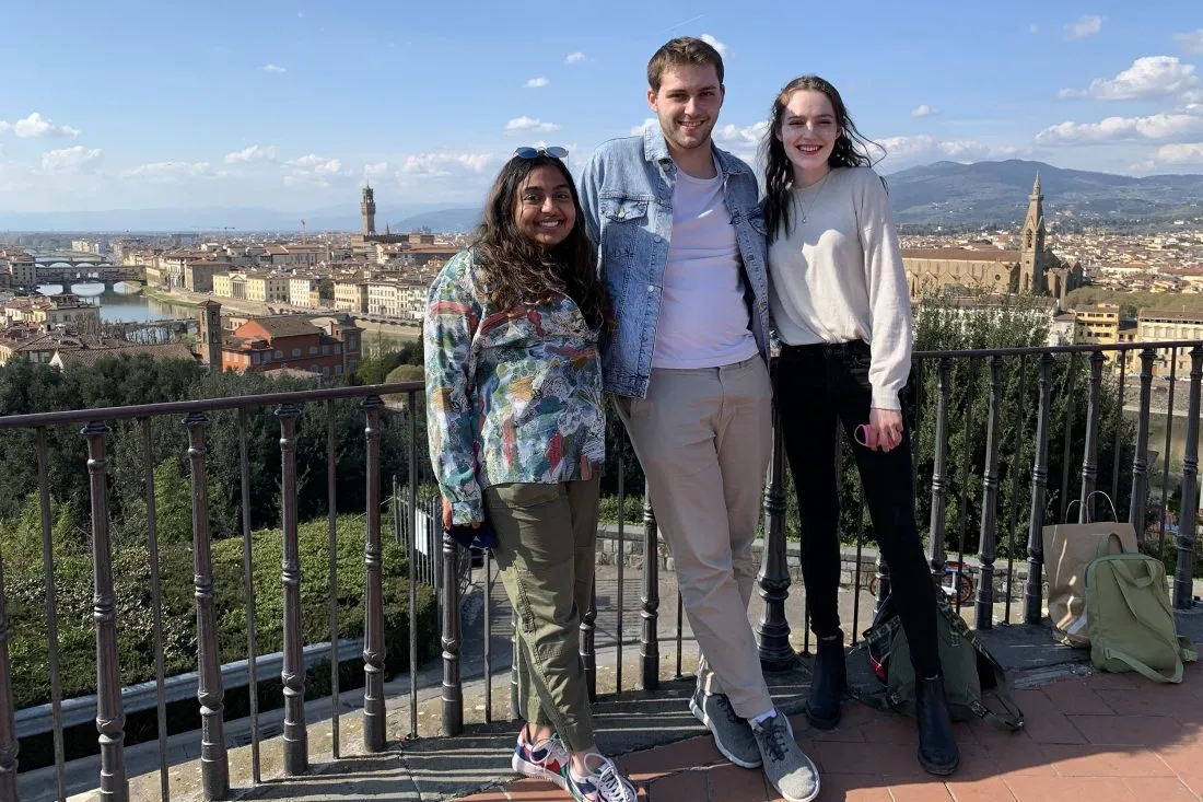 Students pose for a photo with foreign cityscape behind them.