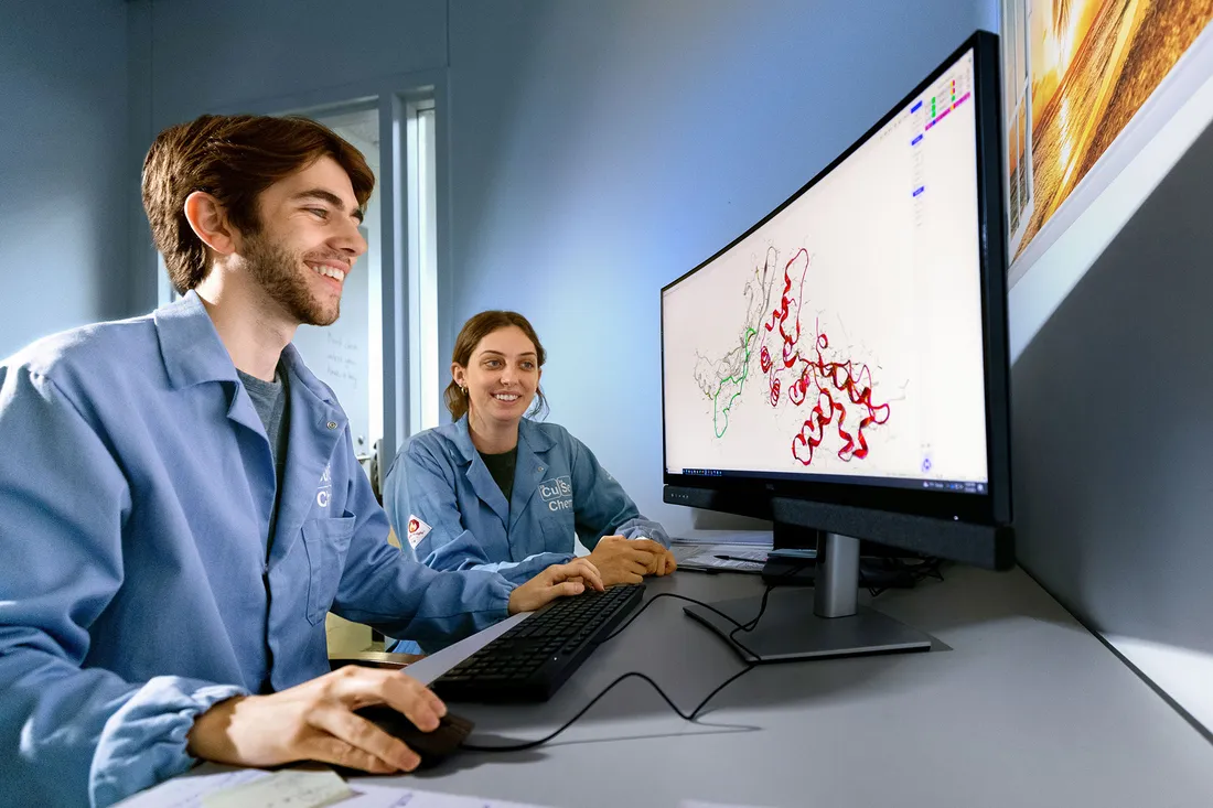 Two students work together at computer in lab.