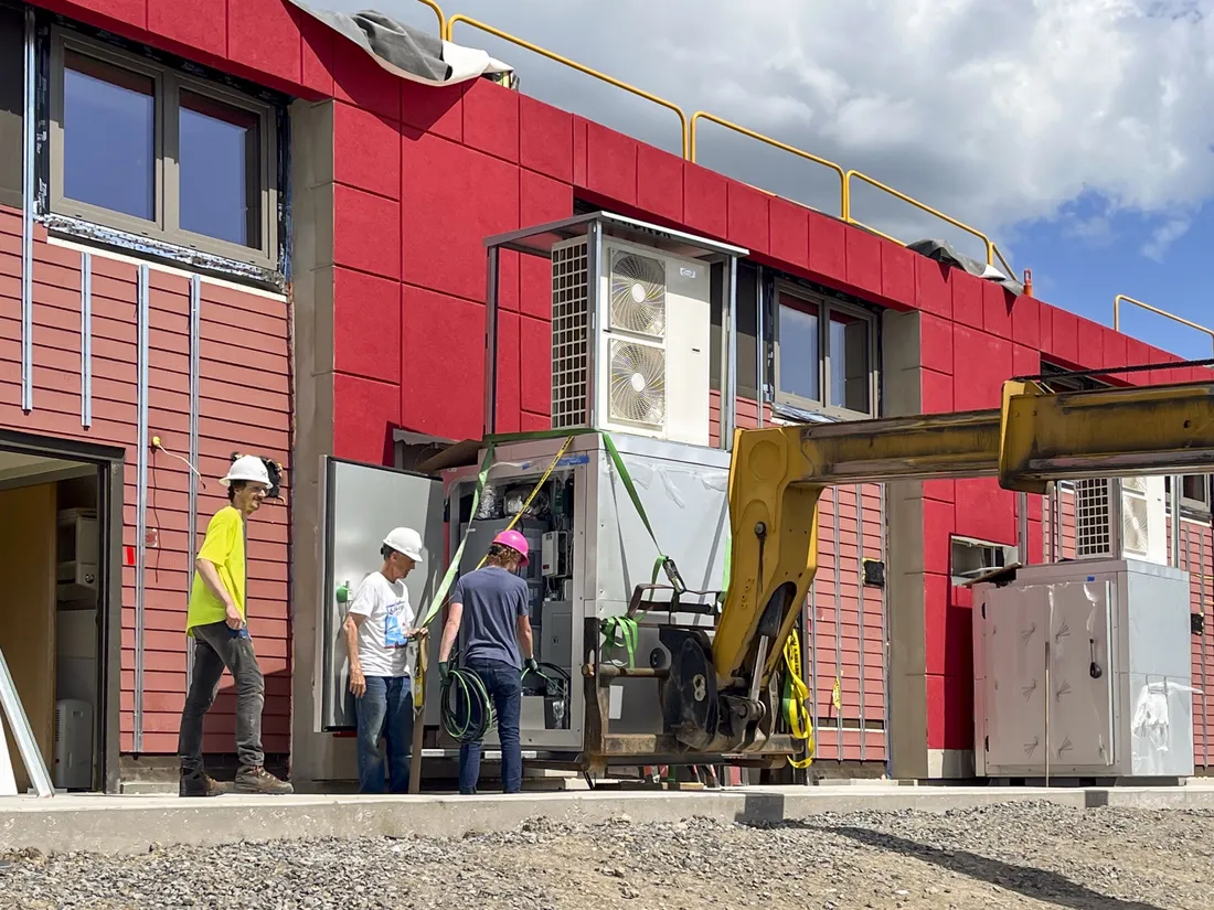 Members of a construction team installing the South Campus retrofit project's unique outdoor HVAC system.
