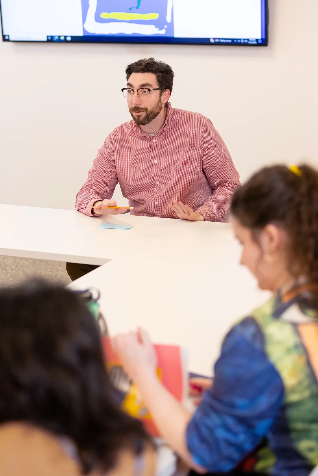 Professor talking to students in classroom.