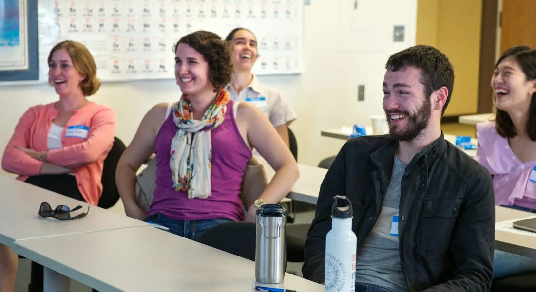 Students laughing together in a classroom.
